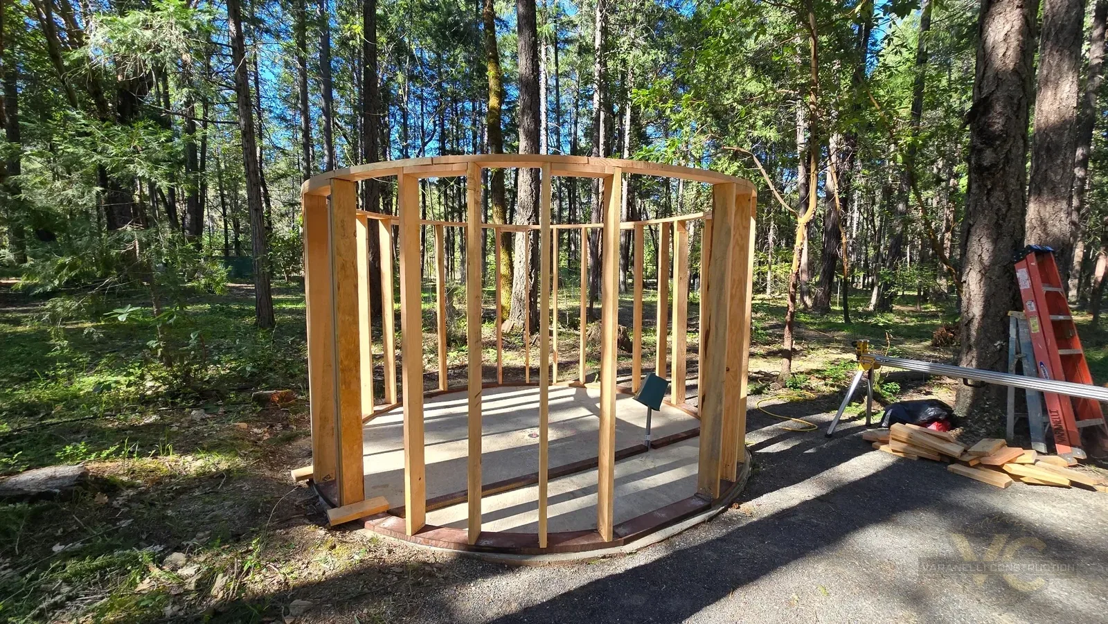 Custom round sauna wall framing standing around the circular foundation in a wooded Applegate Valley setting