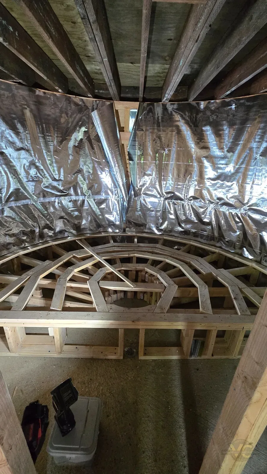 Interior of round sauna showing roof framing and reflective interior preparation during construction