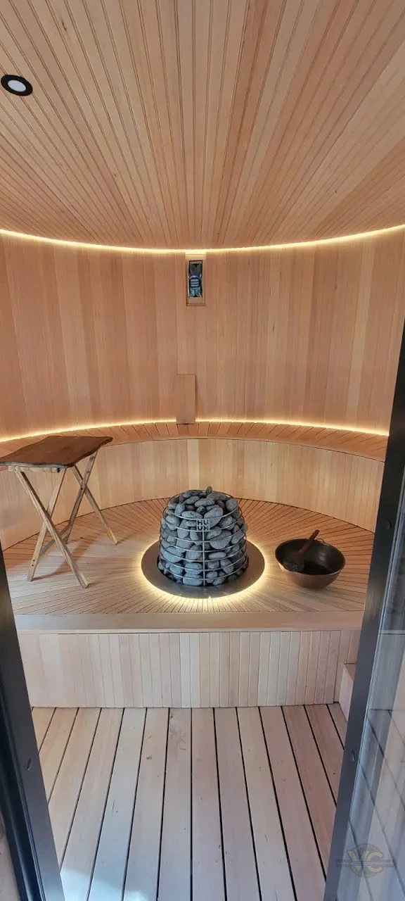 Finished custom sauna with central heater, radial platform and illuminated curved bench