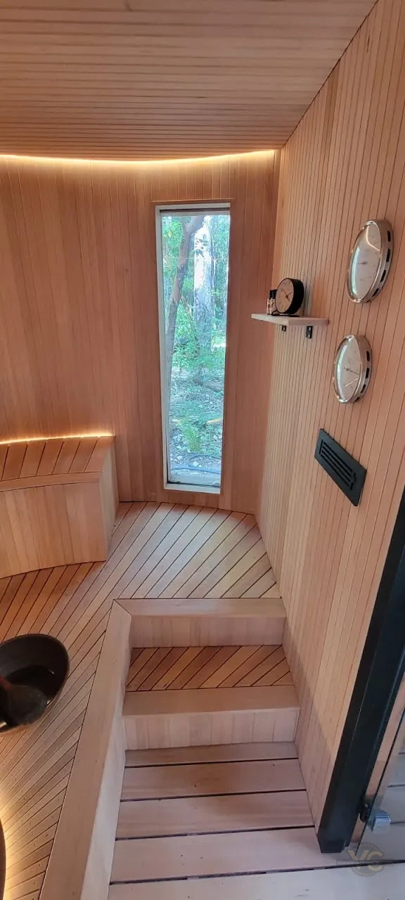 Finished sauna interior in the Applegate Valley with tall narrow window, wood seating and wall gauges
