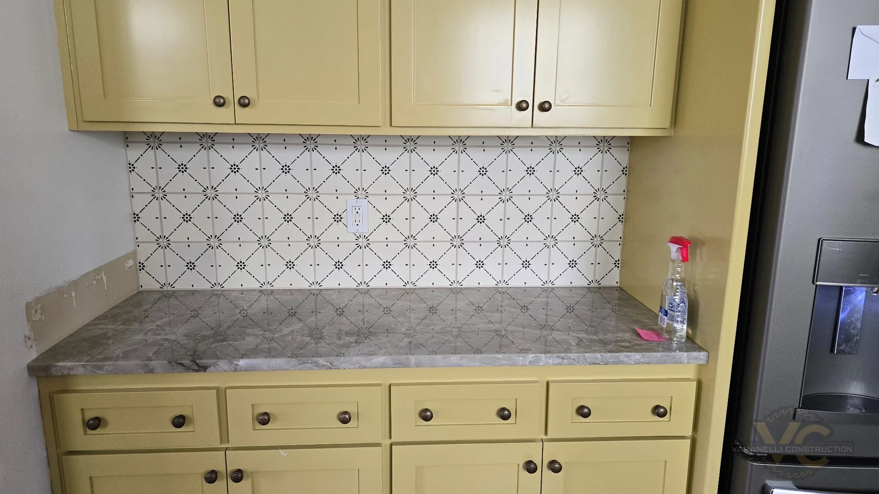 Finished Ashland coffee nook with green custom cabinetry, stone countertop and patterned tile backsplash