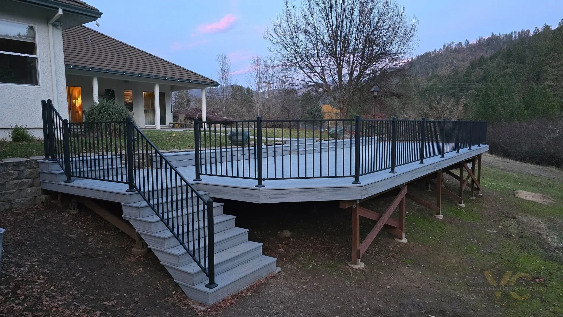 Finished large Trex deck with black metal railing in Gold Hill, Oregon