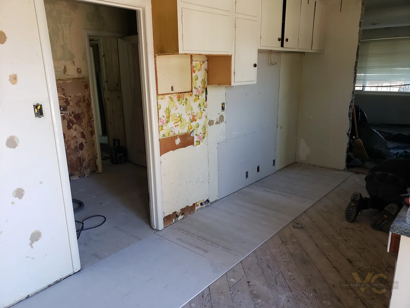 Dated Grants Pass kitchen before Varanelli Construction remodel with old cabinets and partially removed wall finishes