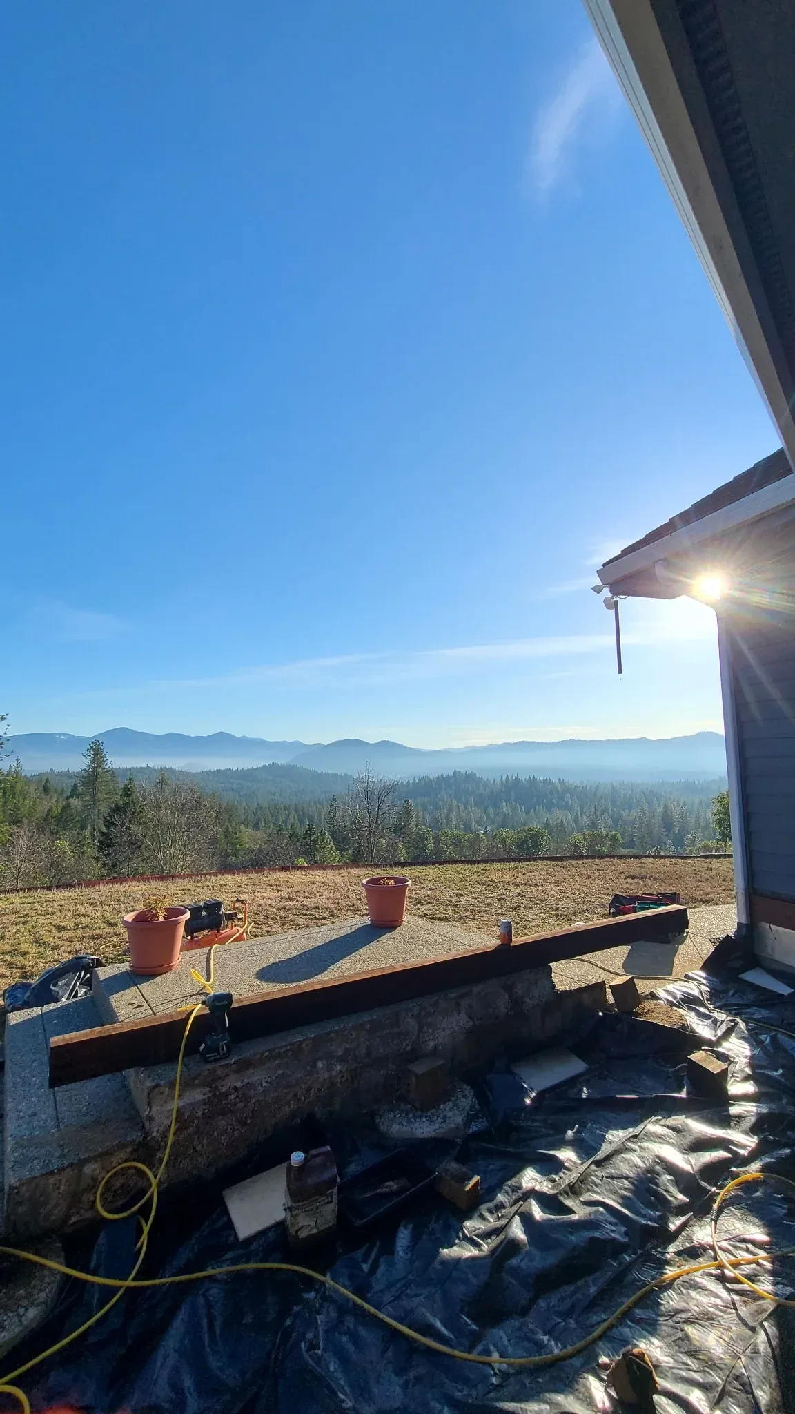 Old deck removed during a Grants Pass deck replacement with mountain view visible beyond the work area