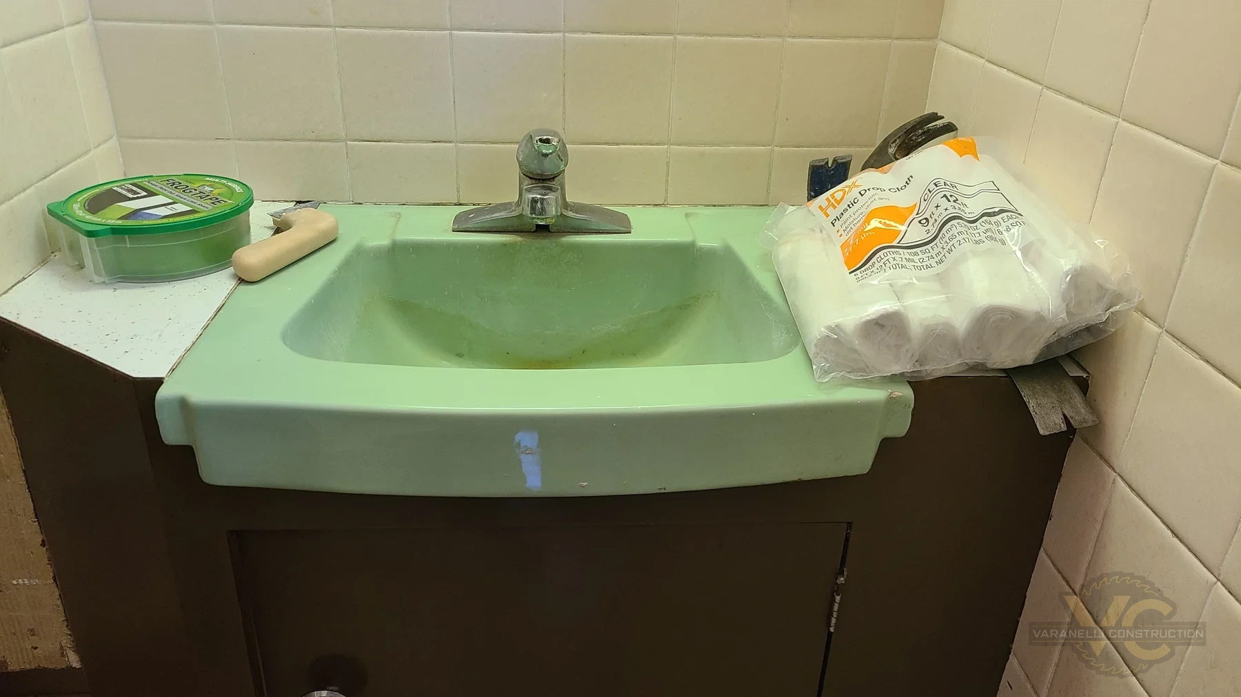Original green sink and dated wall tile before a small Grants Pass bathroom remodel