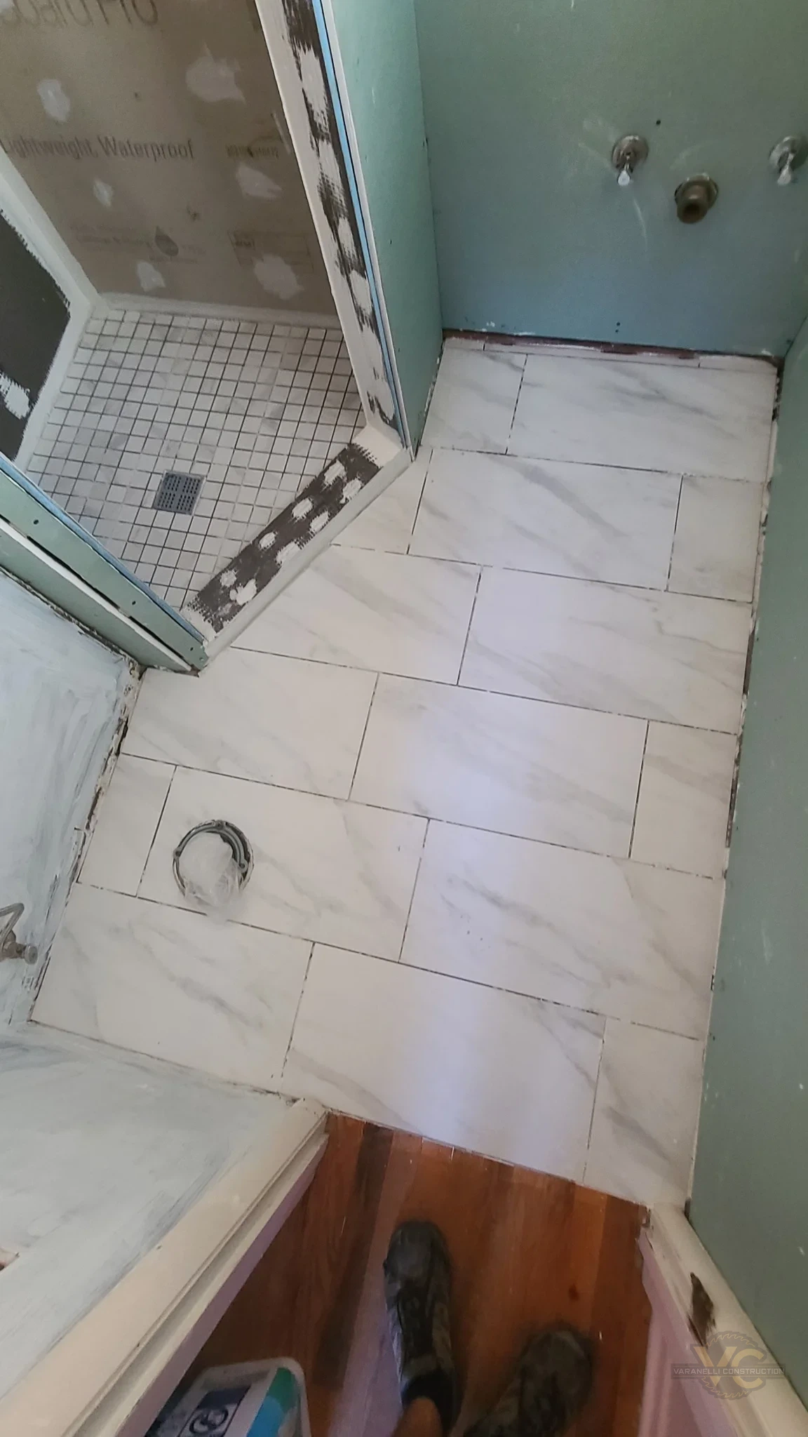 Marble-look bathroom floor tile and shower floor tile being installed in Grants Pass