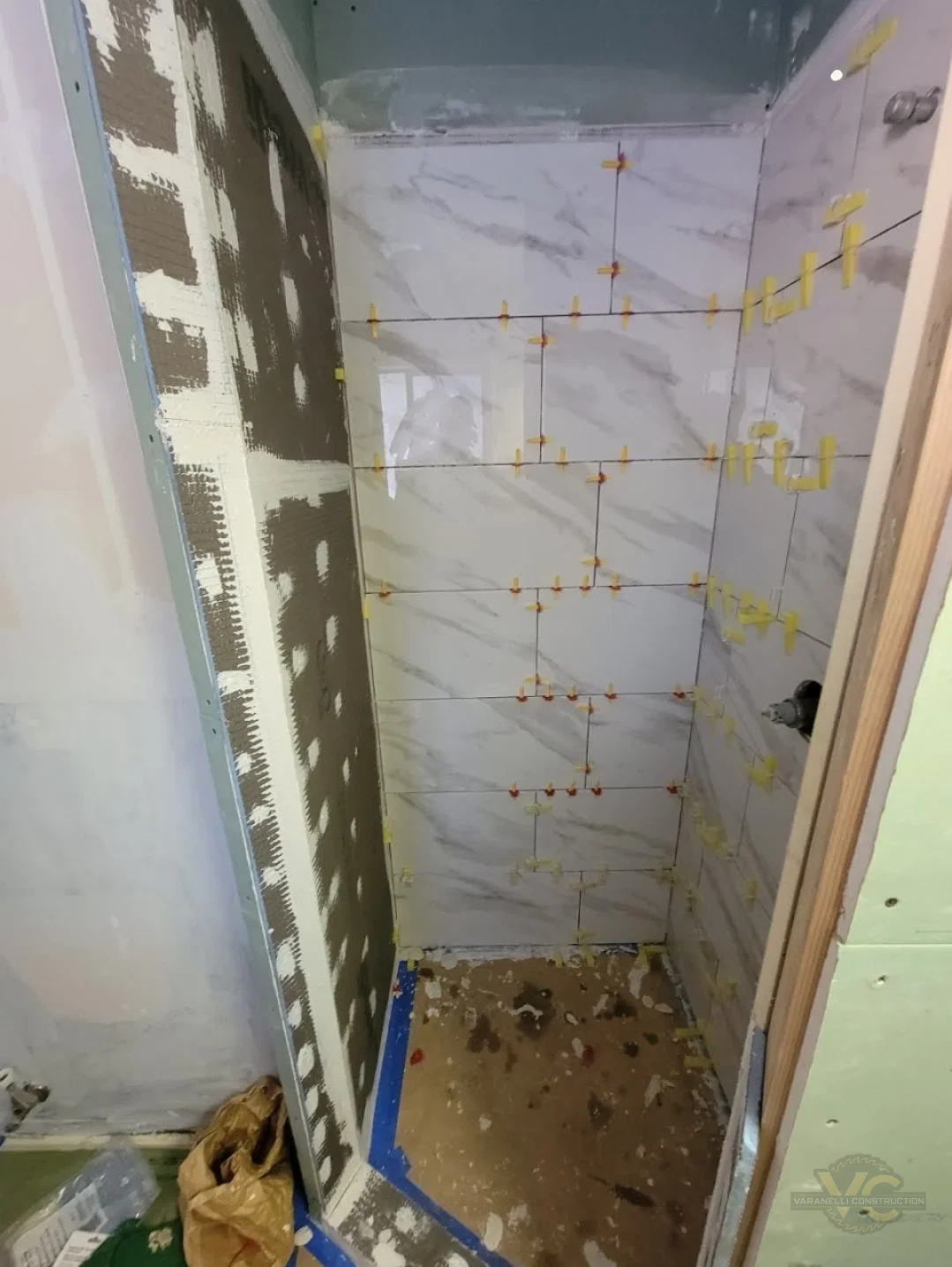 Large-format marble-look shower tile being installed during a Grants Pass bathroom remodel