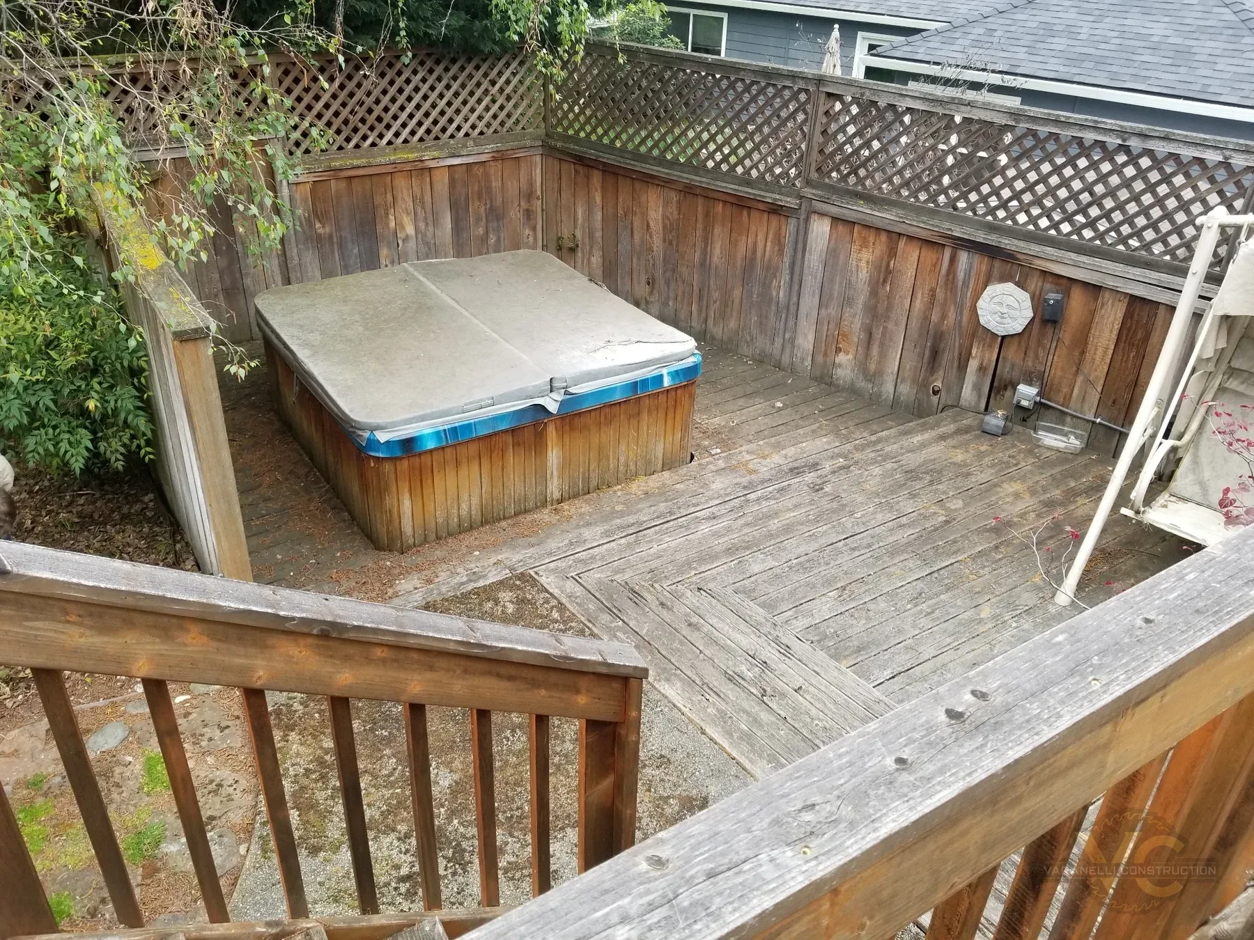 Old lower deck area with inset hot tub before removal in Medford