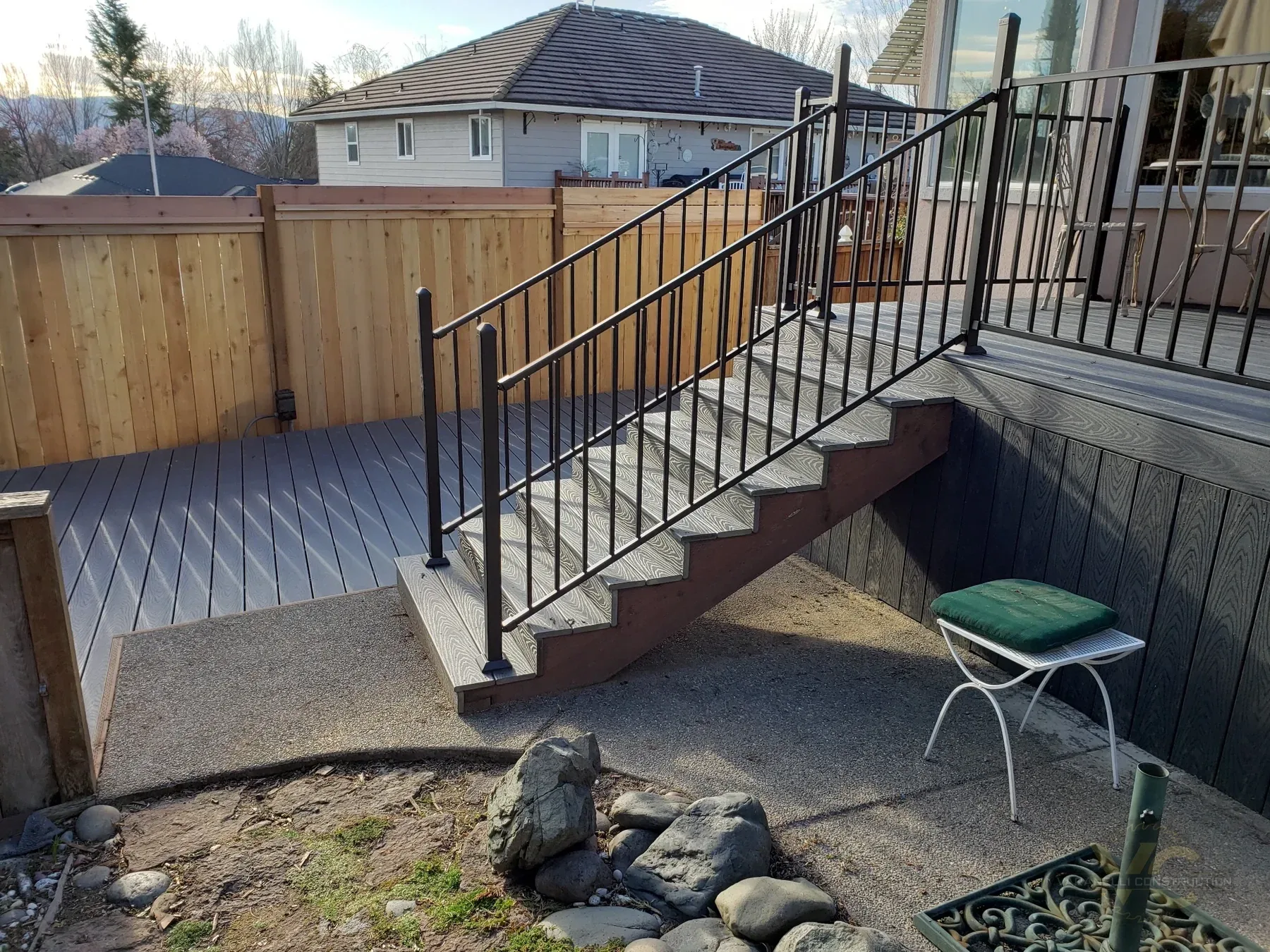 Finished Medford split-level Trex deck with stairs, black metal railing and new cedar fence