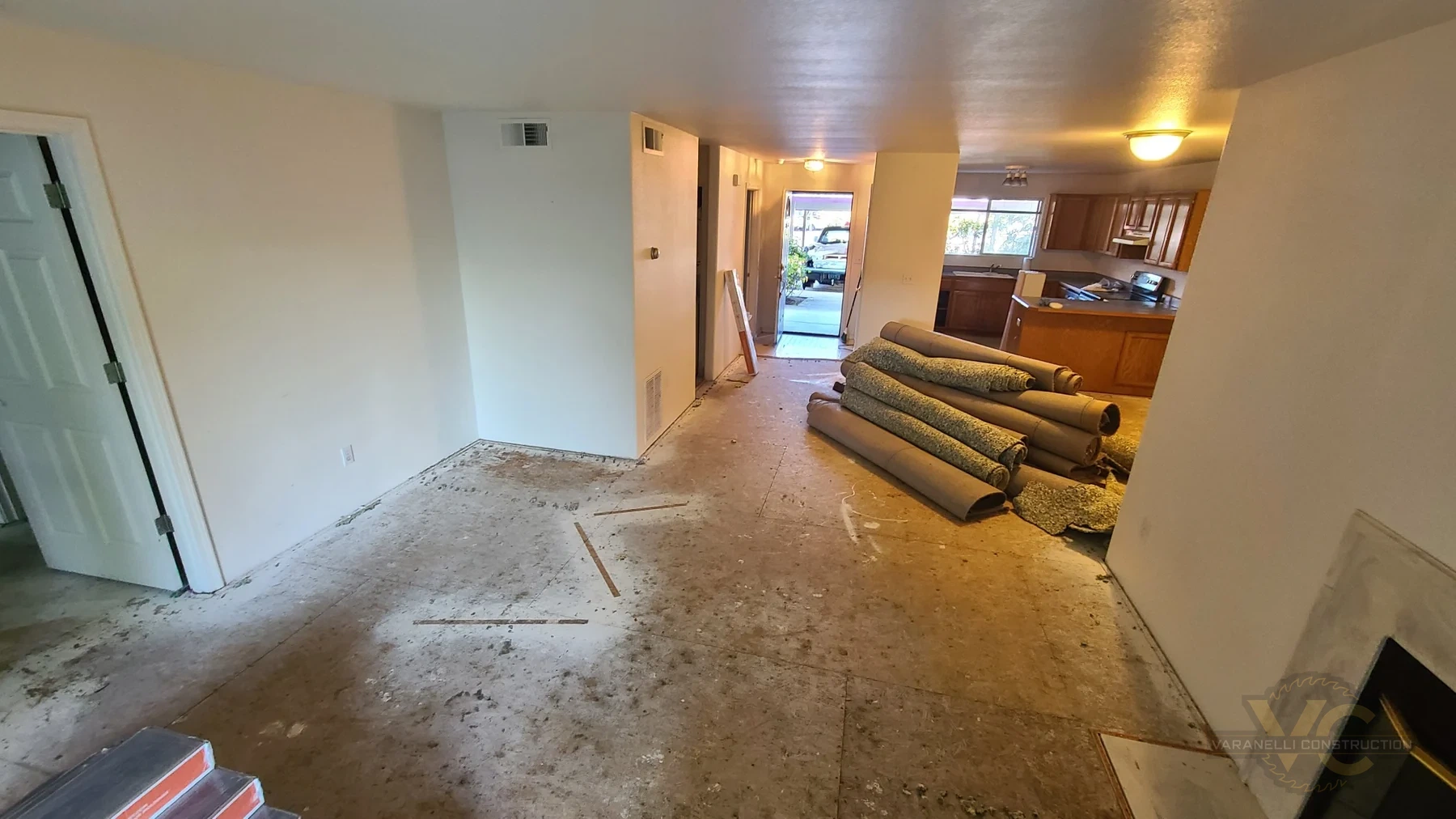 Large living area after carpet removal with exposed subfloor in Rogue River