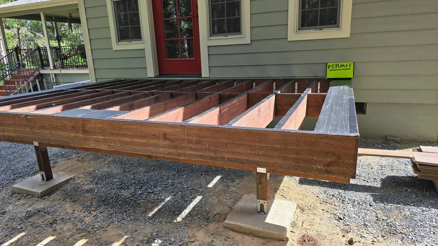 Pressure-treated deck frame with joists and blocking taped before composite decking installation in Rogue River
