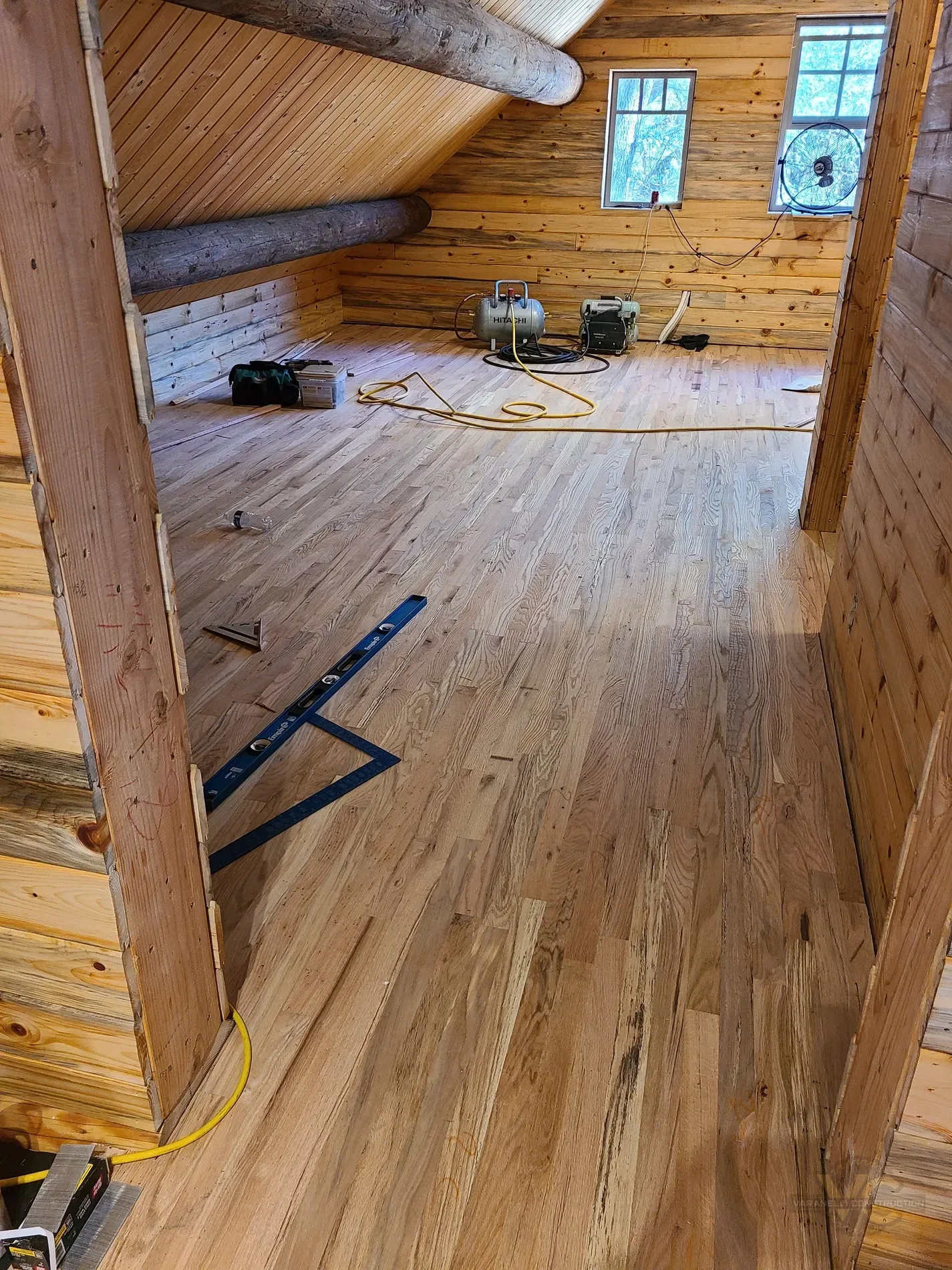 Wood flooring renovation inside a log home by Varanelli Construction