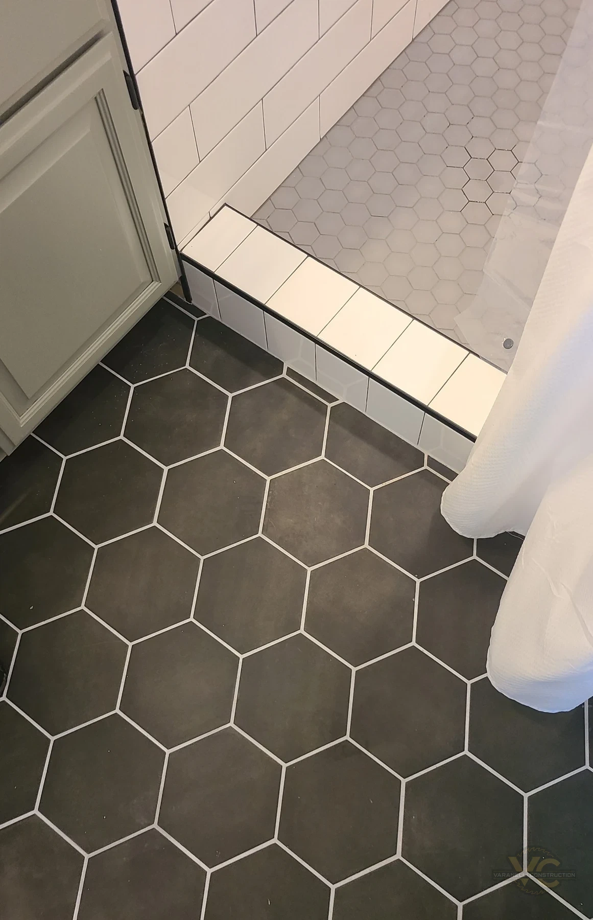 Hex bathroom floor tile and tiled shower threshold by Varanelli Construction