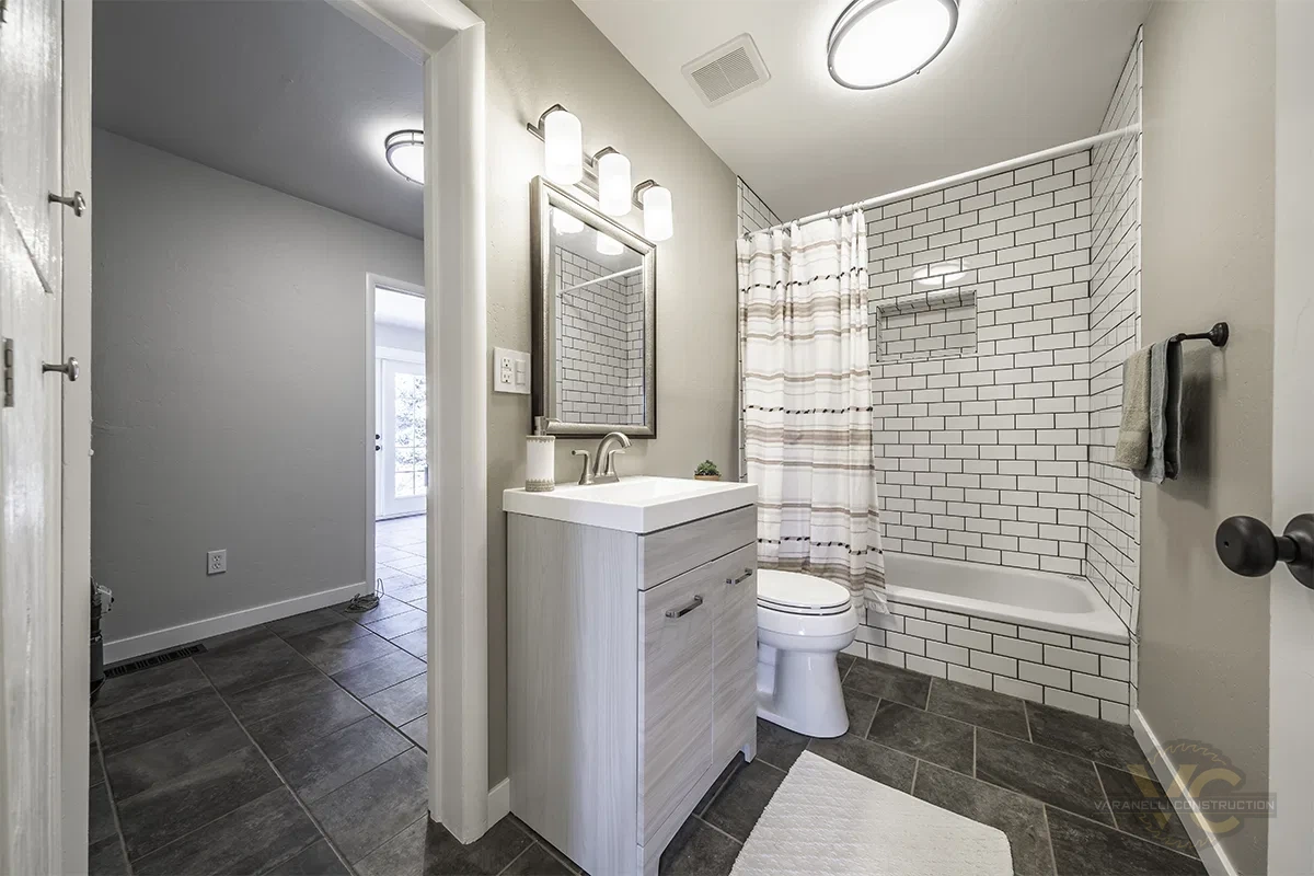 Finished bathroom with subway tile shower and tiled floor by Varanelli Construction